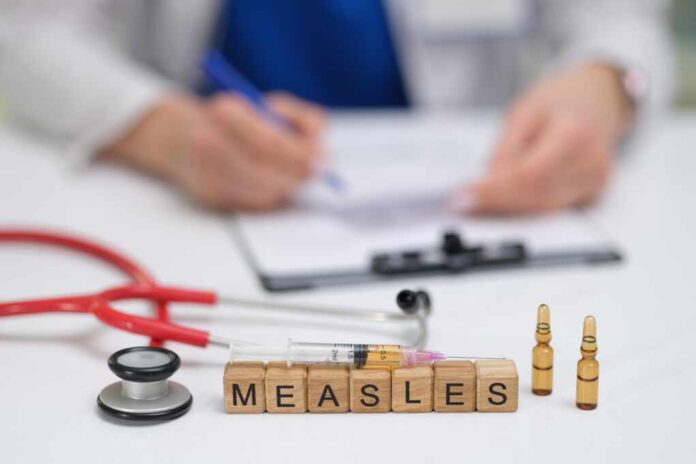 A,Doctor,Carefully,Documents,The,Measles,Vaccination,Process,,Noting,The