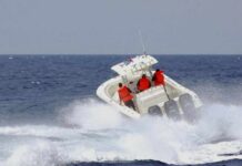 A speedboat with passengers navigating through rough ocean waves