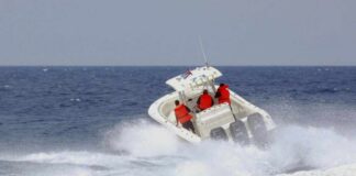 A speedboat with passengers navigating through rough ocean waves
