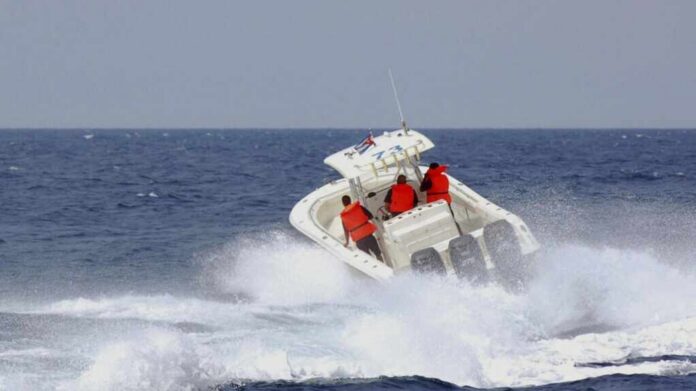 A speedboat with passengers navigating through rough ocean waves
