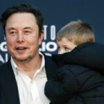 Altman vs. Musk: Orbital Data Centers Feud A man in a black suit holding a child in a coat at a public event
