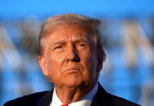 Close-up portrait of a serious-looking political figure outdoors