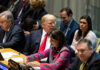 A group of political leaders seated at a United Nations meeting, engaged in discussion