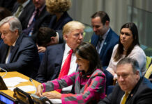 A group of political leaders seated at a United Nations meeting, engaged in discussion
