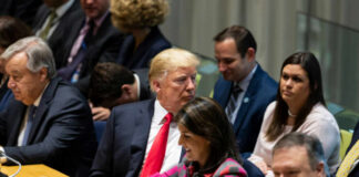 A group of political leaders seated at a United Nations meeting, engaged in discussion