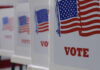 Voting booths with American flags and VOTE signage