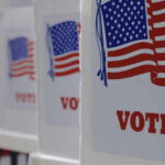 Voting booths with American flags and VOTE signage