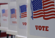 Voting booths with American flags and VOTE signage