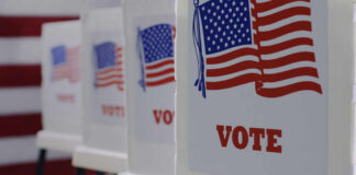 Voting booths with American flags and VOTE signage