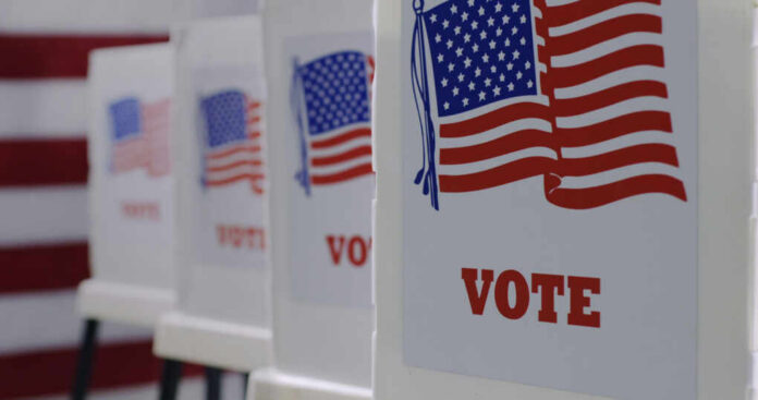 Voting booths with American flags and VOTE signage