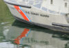 Close-up of a U.S. Coast Guard boat with reflections in the water