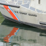 Close-up of a U.S. Coast Guard boat with reflections in the water