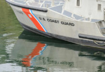 Close-up of a U.S. Coast Guard boat with reflections in the water