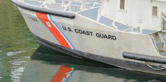 Close-up of a U.S. Coast Guard boat with reflections in the water