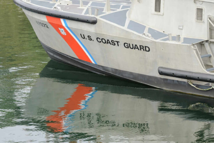 shutterstock_2240153199.jpg Close-up of a U.S. Coast Guard boat with reflections in the water