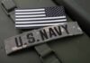U.S. Navy patch and American flag on a green military surface
