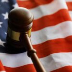 A wooden gavel resting on an American flag