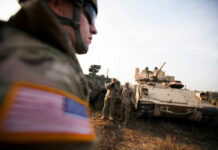 M1E3 Abrams Risks Battlefield Debut Unproven Soldiers in military gear coordinating near armored vehicles during training