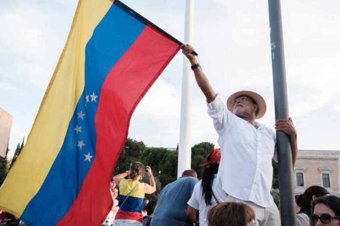 Man holding a Venezuelan flag during a protest