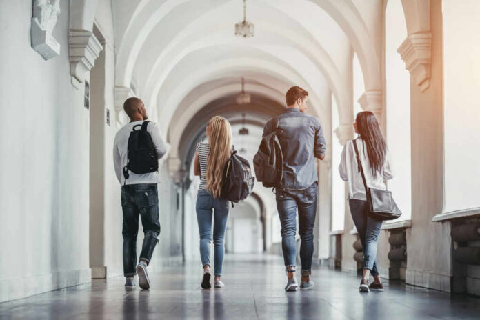 Group of students walking together in a university hallway