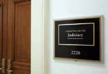 Sign for the Committee on the Judiciary outside a room with wooden doors
