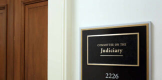 Sign for the Committee on the Judiciary outside a room with wooden doors