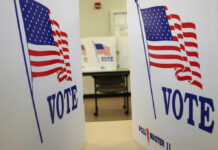 Voting booths with American flags and the word VOTE displayed