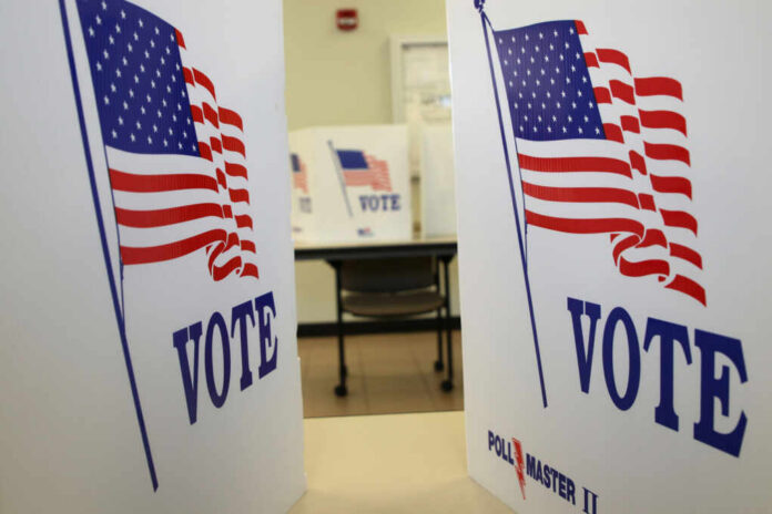 Voting booths with American flags and the word VOTE displayed