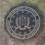 Bronze seal of the FBI mounted on a stone wall