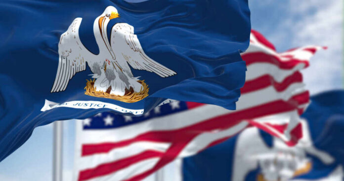 Close-up of the Louisiana state flag with an American flag in the background