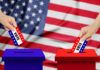 A hand placing a vote into a ballot box with an American flag background