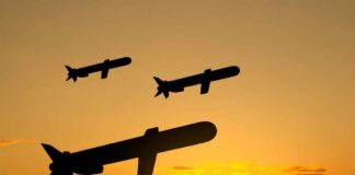 Silhouetted missiles flying against a sunset backdrop