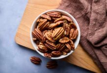 Bowl of pecans on a wooden cutting board