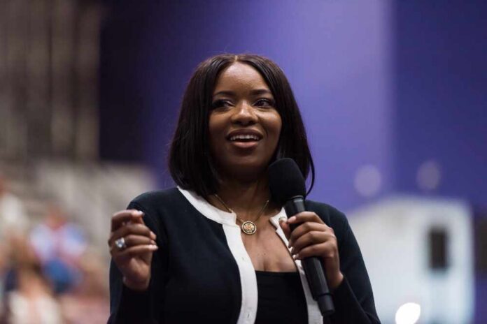 A woman speaking into a microphone at a conference