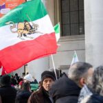 Crowd holding Iranian flags during a protest