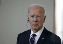 Biden Alleged Delaware Sighting Raises Eyebrows A serious-looking man in a suit with an earpiece, standing indoors