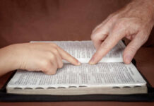 Canada’s Bold Bill: Faith Leaders Sound Alarm A childs hand and an adults hand pointing at text in a book