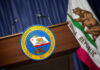 Podium with the seal of the Governor of California and state flag in the background
