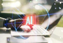 A hand interacting with a laptop displaying an AI symbol