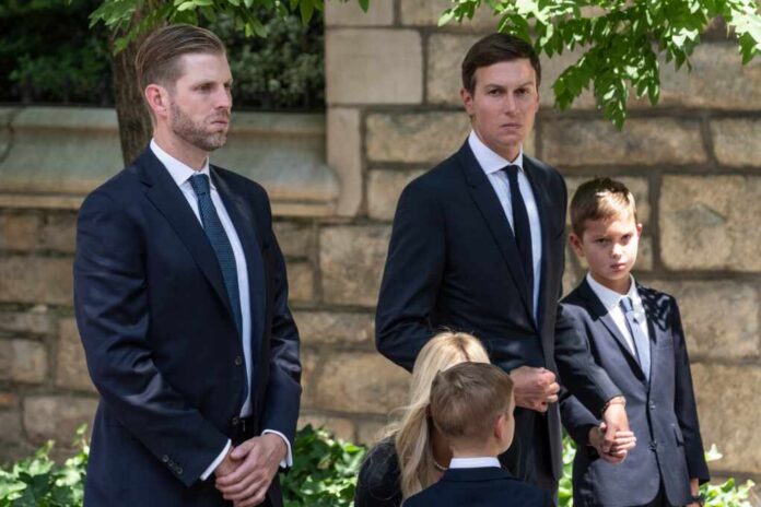 shutterstock_2180696079.jpg A group of men and children in formal attire standing outdoors, appearing serious