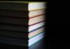 A stack of books with colorful spines against a dark background