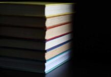 A stack of books with colorful spines against a dark background