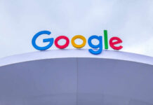 Colorful Google logo displayed on a modern structure against a cloudy sky