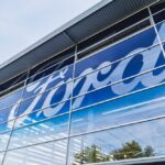 U.S. Auto Market Faces Chinese Invasion Threat Exterior view of a Ford dealership with a large logo on the glass