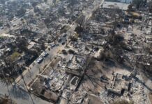 Haifa Horror: Missile Leaves Total Devastation Aerial view of a neighborhood devastated by wildfire, showing burned structures and debris
