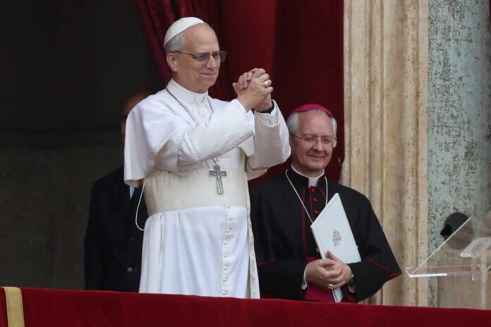 shutterstock_2626718303.jpg A religious leader in white robes gestures during a public address