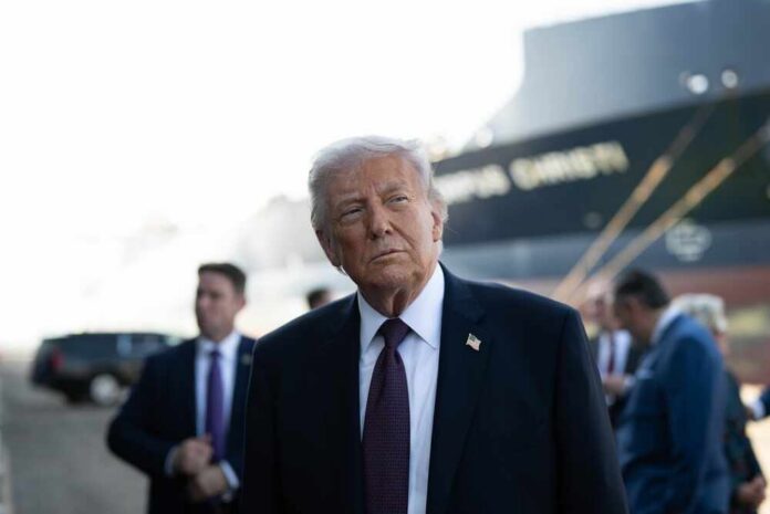 shutterstock_2747572781.jpg A political figure in a suit looking thoughtfully at an outdoor event with a ship in the background