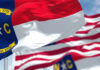 North Carolina state flag waving in the wind with historical dates