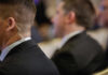 Security personnel in formal attire with an earpiece at a business event