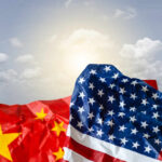 Beijing’s Secret Agent in Arcadia Exposed Crumpled flags of the United States and China against a cloudy sky